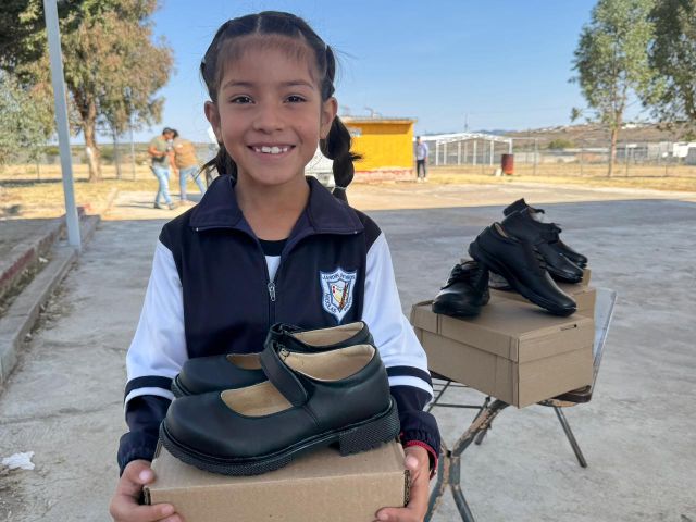 Alegría de muchas y muchos escolares al recibir sus zapatos una nina